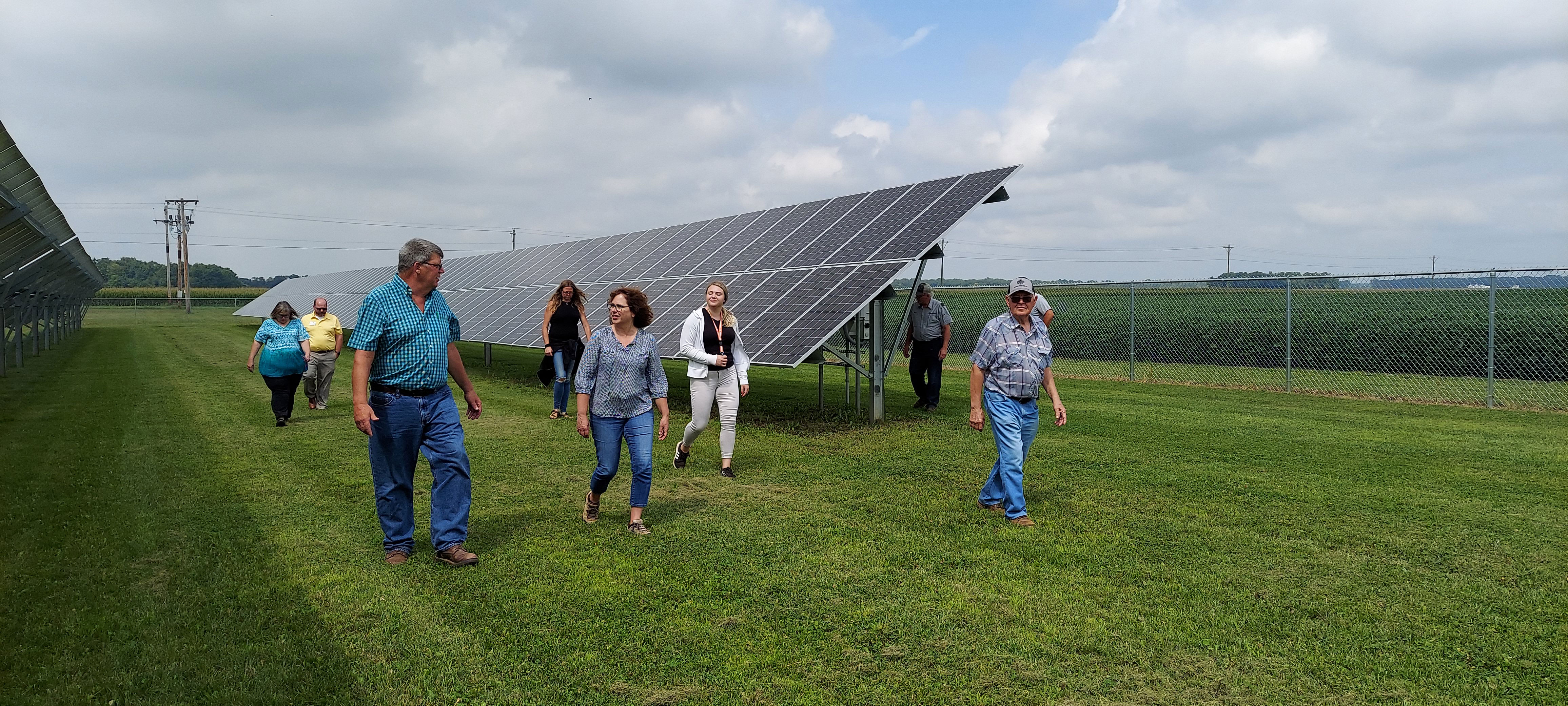Lenawee County grain farmer Gary Gallup (left) leads tour attendees down the length of a seven-acre solar farm nestled between his corn and soybean fields north of Morenci.