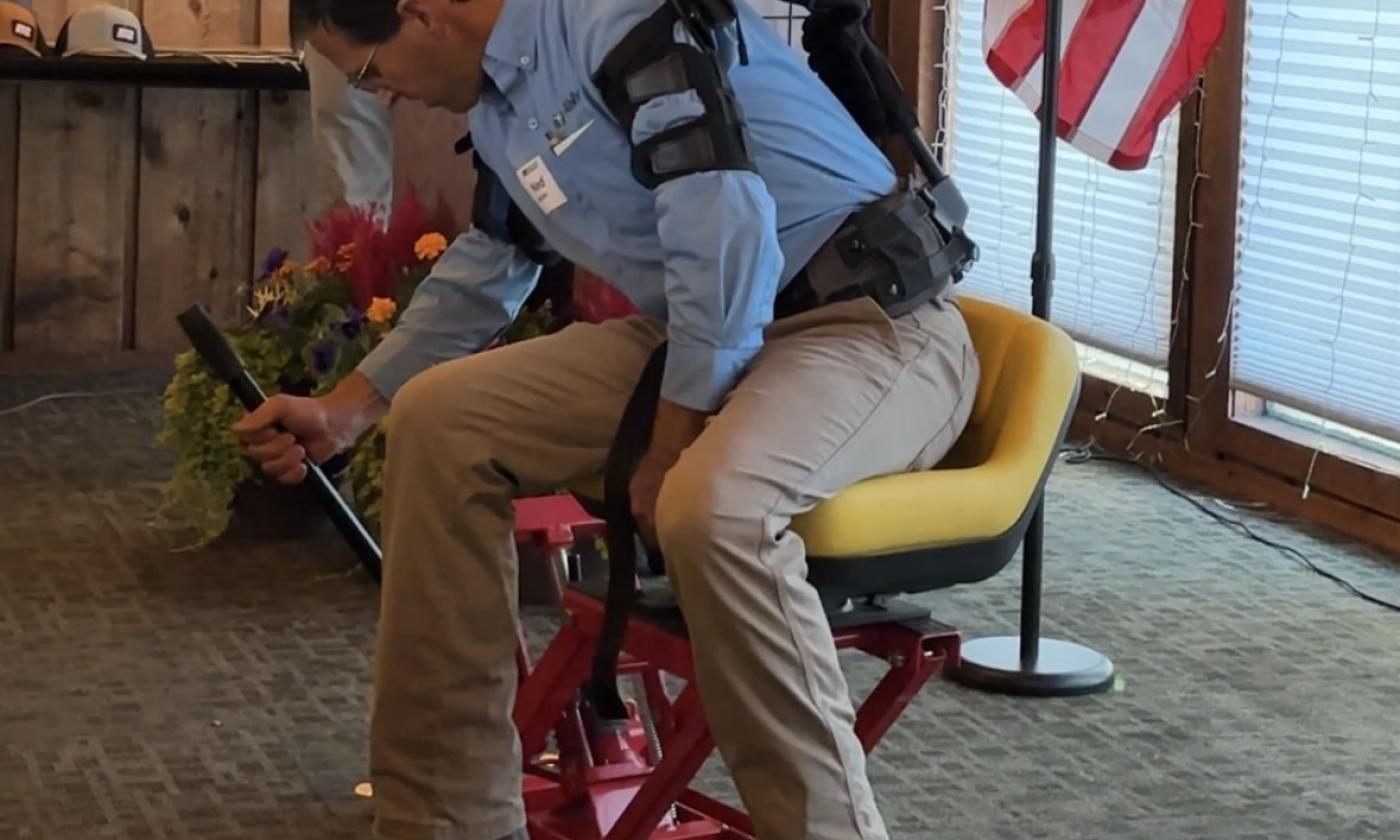 Ned Stoller of Michigan AgrAbility demonstrates a piece of adaptive equipment he created.