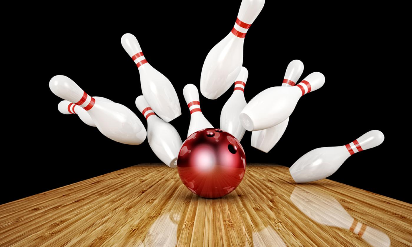 A bowling ball hitting bowling pins.