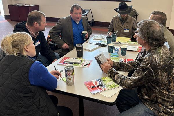 A group of six Farm Bureau members talking at a table.