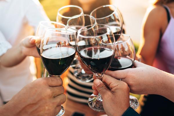 Seven people clinking their glasses of wine together.
