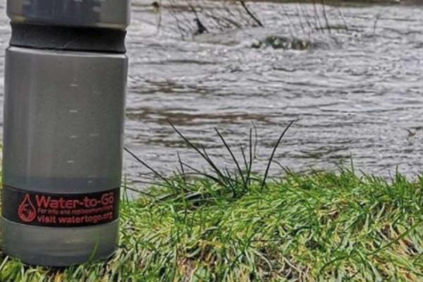Water to Go bottle on riverbank.