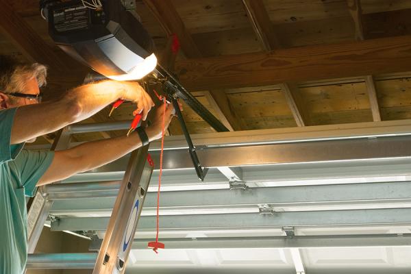 A man servicing a garage door opener.
