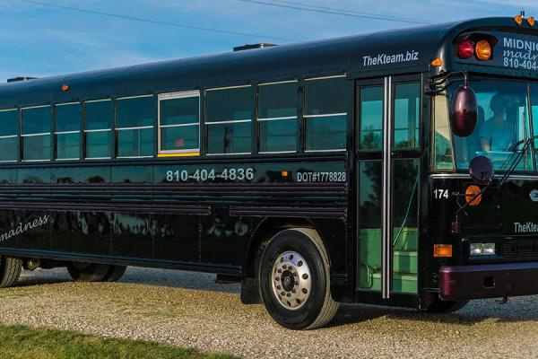 A black bus with &quot;MIDNIGHT MADNESS&quot; written on it.