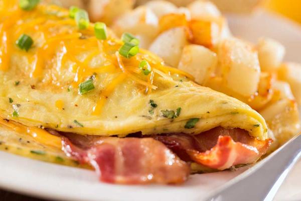 A folded egg omelet filled with chopped ham and vegetables.