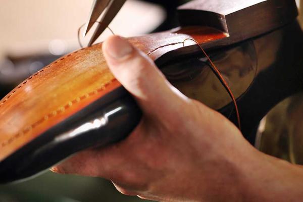 Close up of a leather shoe being resoled by a cobbler.