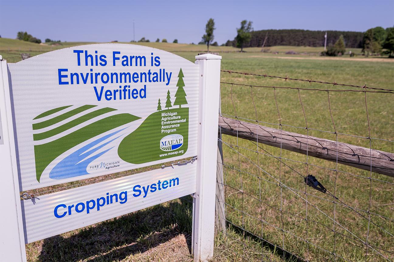 A sign posted next to a field reading &quot;THIS FARM IS ENVIRONMENTALLY VERIFIED.&quot;