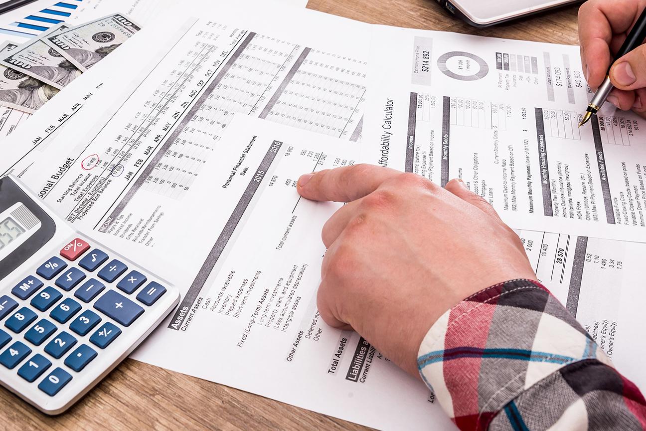 Close-up of a farmers hands as he works on tax forms.