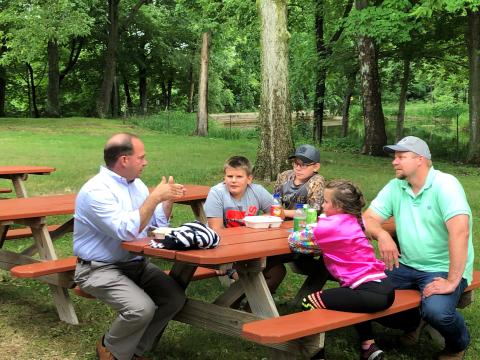 Michigan Farm Bureau CEO Scott Piggott (left) visits with Berrien member Brett Marschke and his family.