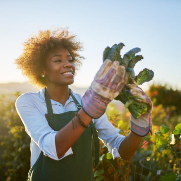 Woman smiles while looking at kale