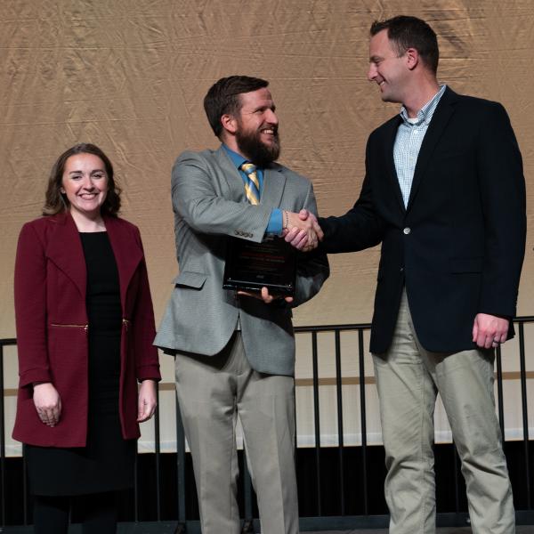 A man receiving a Young Farmer award on stage at the State Annual Meeting.