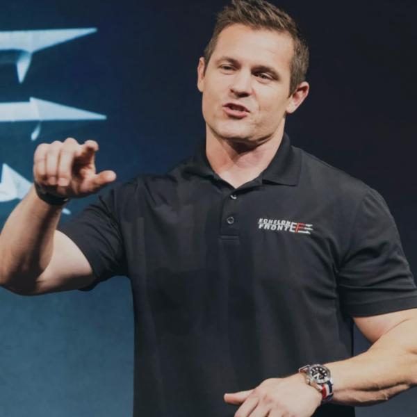 Portrait of Sean Glass speaking on stage during a presentation.