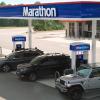 Wide aerial shot of a Marathon gas station with cars parked at the gas pumps during the day time.