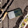 Focused view of a fishing rod next to a tackle box.