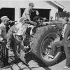 Gerald Ford makes a campaign stop at a farm in Kent County, Michigan 1948. He has his foot on the back tire of a tractor while talking with 3 farmers.