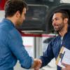 Man greeting a mechanic with a handshake at an auto repair shop